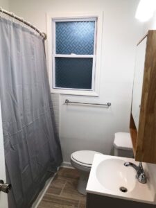 Photograph of brand new bathroom with plenty of storage and tub/shower combo with luxury shower curtain in the fully furnished unit for rent to traveling nurses in Johnson city